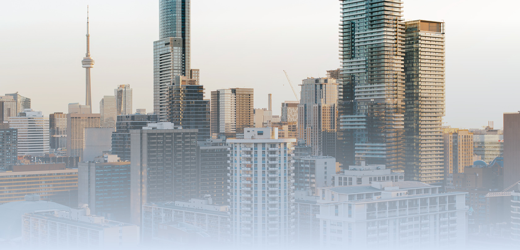 Toronto skyline with the CN Tower and a mix of condo towers and older apartment buildings.
